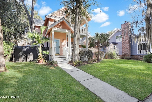 view of front of property with a balcony and a front yard