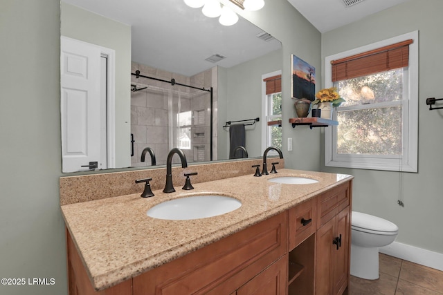 bathroom with vanity, tile patterned floors, toilet, and tiled shower