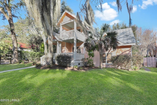 view of front of property featuring a front lawn and a balcony