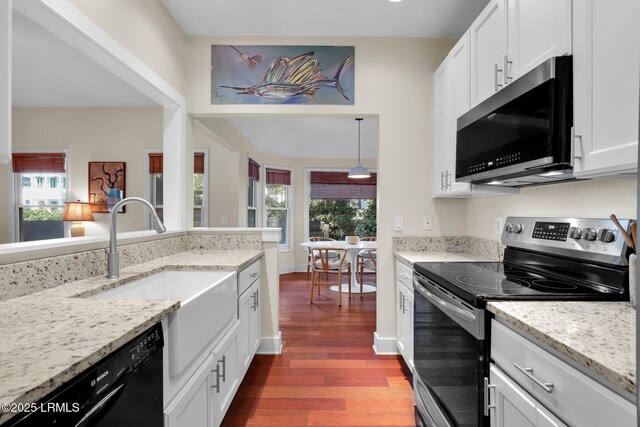 kitchen with sink, light stone counters, hanging light fixtures, stainless steel appliances, and white cabinets