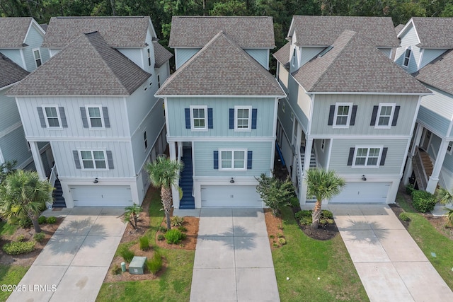 123 Sandcastle Ct, Hilton Head Island, SC 29928 - raised beach house featuring roof with shingles, board and batten siding, concrete driveway, and stairway