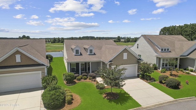 509 Nautical Ln, Okatie, SC 29909 - view of front of house featuring concrete driveway, a front yard, an attached garage, and a water view