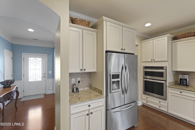 509 Nautical Ln, Okatie, SC 29909 - kitchen featuring stainless steel appliances, dark wood-style flooring, crown molding, decorative backsplash, and light stone countertops
