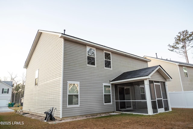 back of property with a sunroom and a yard