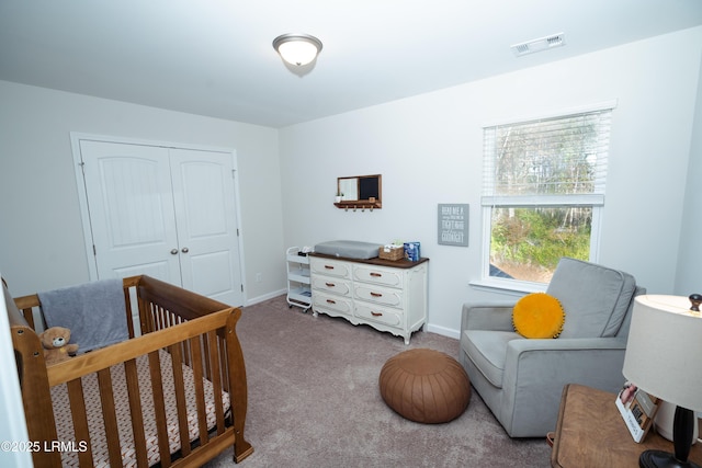 bedroom featuring carpet floors, a crib, and a closet