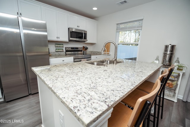 kitchen featuring white cabinetry, a center island with sink, and appliances with stainless steel finishes