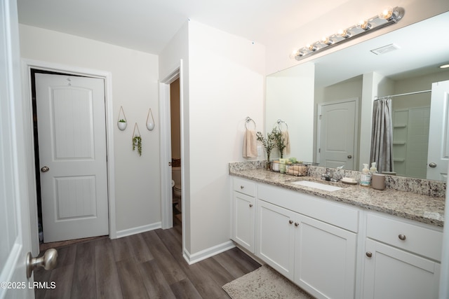 bathroom with vanity, wood-type flooring, toilet, and walk in shower