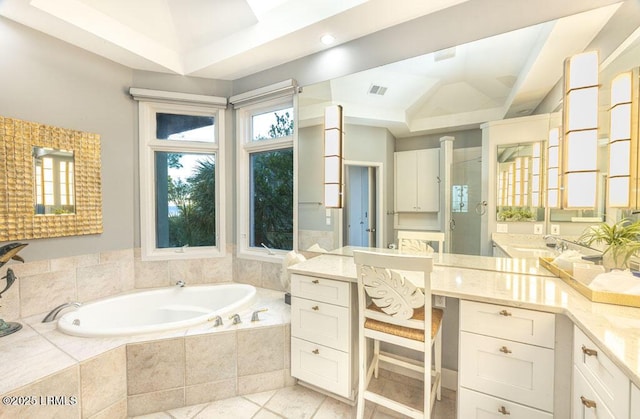 bathroom featuring a relaxing tiled tub, vanity, and vaulted ceiling