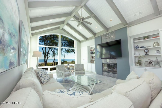 living room featuring high vaulted ceiling, built in features, beamed ceiling, ceiling fan, and a fireplace