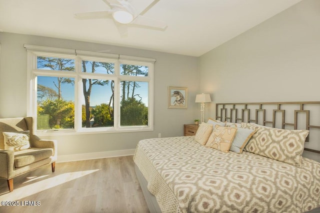 bedroom featuring ceiling fan, light hardwood / wood-style floors, and multiple windows