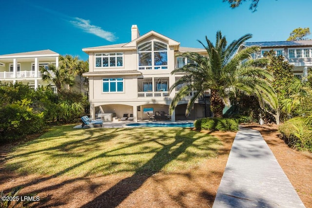 rear view of house featuring a yard and a patio area