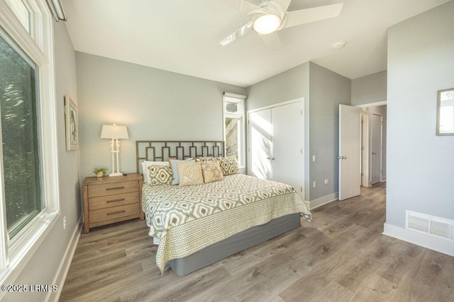 bedroom with a closet, ceiling fan, and light wood-type flooring