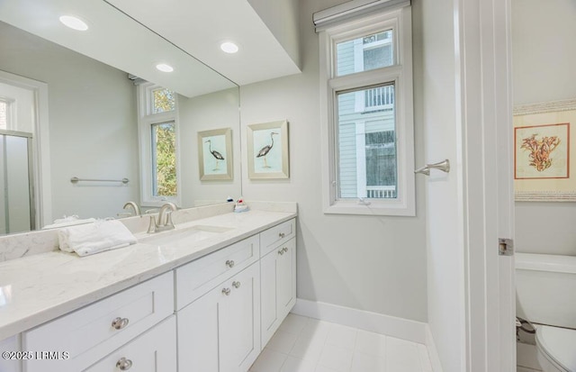 bathroom featuring vanity, a wealth of natural light, and toilet