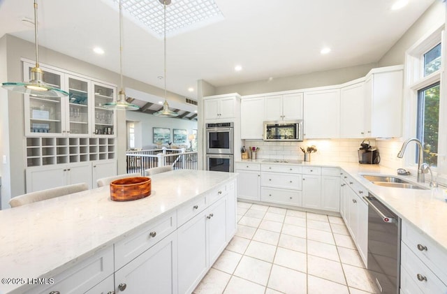 kitchen featuring sink, hanging light fixtures, white cabinets, and appliances with stainless steel finishes