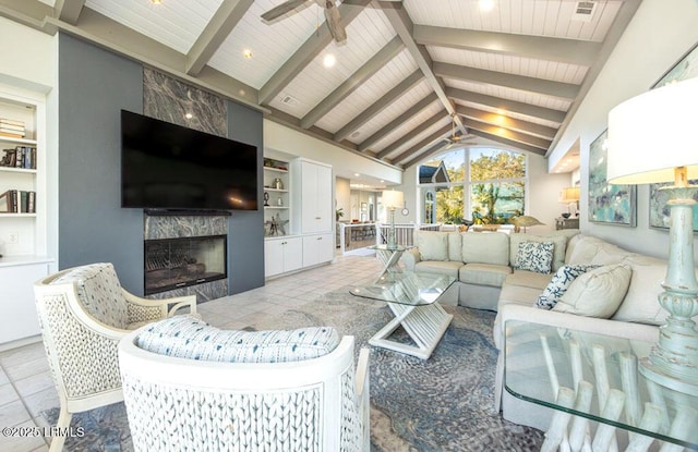 living room with lofted ceiling with beams, a premium fireplace, ceiling fan, and light tile patterned flooring