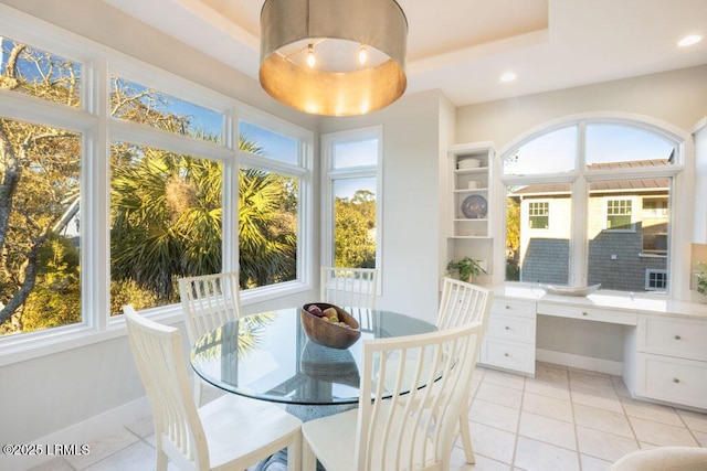 sunroom featuring a tray ceiling and built in desk