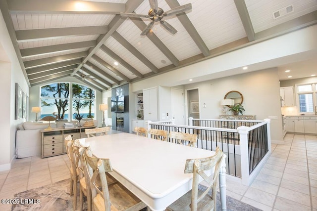 dining area with ceiling fan, beam ceiling, high vaulted ceiling, and light tile patterned floors