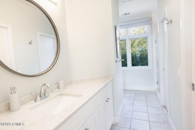 bathroom featuring tile patterned flooring, vanity, and a shower with door