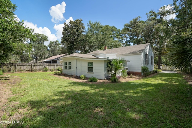 rear view of house featuring a yard