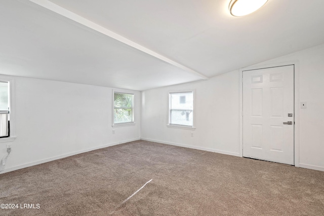 spare room with vaulted ceiling and carpet flooring