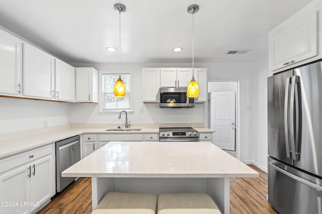 kitchen with pendant lighting, sink, white cabinets, and appliances with stainless steel finishes