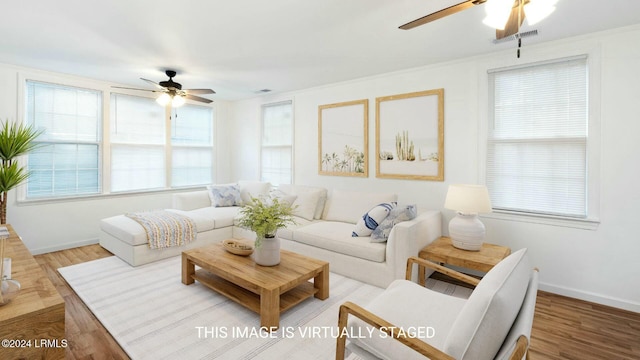 living room featuring ceiling fan, ornamental molding, and hardwood / wood-style floors