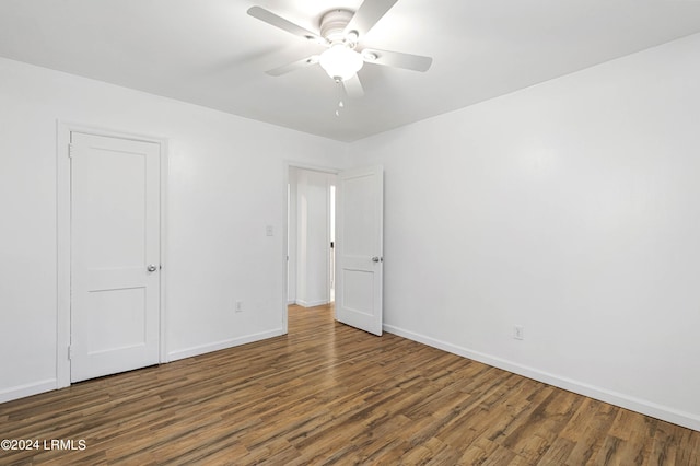 empty room with ceiling fan and dark hardwood / wood-style flooring