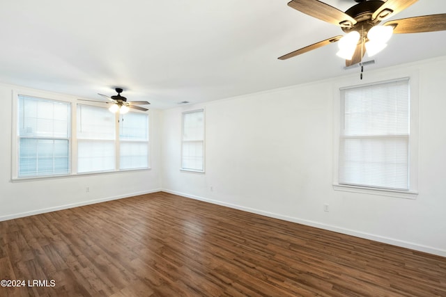 spare room featuring dark wood-type flooring, ornamental molding, and ceiling fan