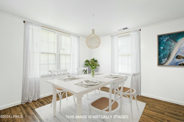 dining area with a healthy amount of sunlight, dark hardwood / wood-style floors, and crown molding