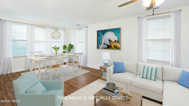 living room featuring crown molding, wood-type flooring, and ceiling fan