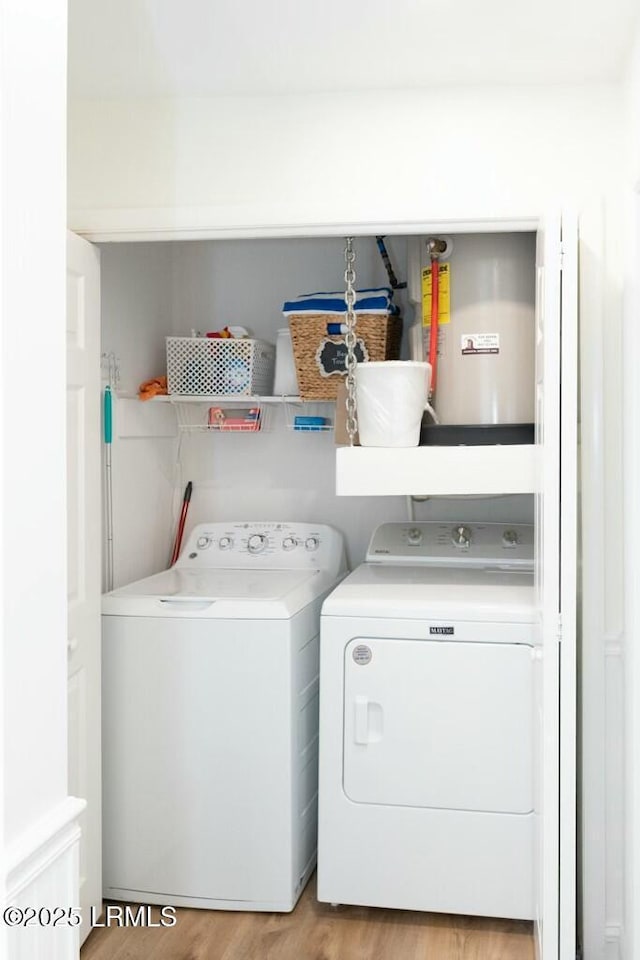 washroom featuring light wood-style flooring, laundry area, and washing machine and dryer