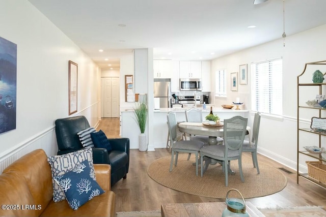 dining room featuring visible vents, light wood finished floors, and recessed lighting