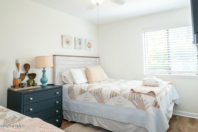bedroom featuring wood finished floors, baseboards, and a ceiling fan