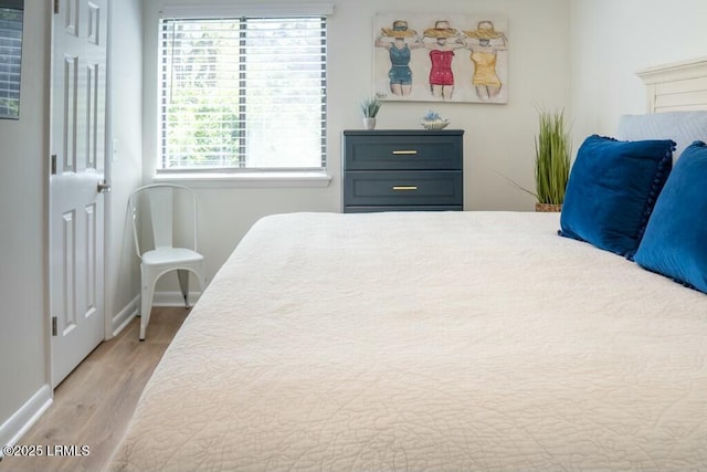 bedroom featuring baseboards and light wood-style floors