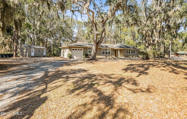 view of front of property with an attached garage and gravel driveway