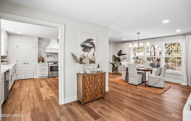 dining area with recessed lighting, a notable chandelier, and light wood finished floors