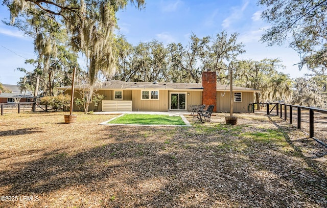 back of house featuring a patio area, a fenced backyard, and a chimney