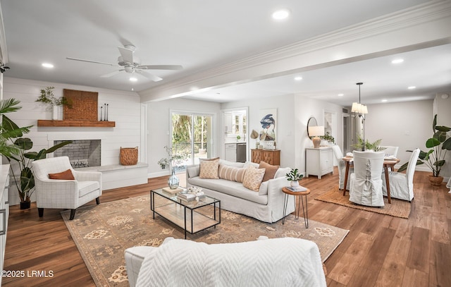 living area featuring recessed lighting, a fireplace, and wood finished floors