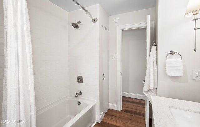 full bath featuring shower / tub combo, baseboards, wood finished floors, and vanity