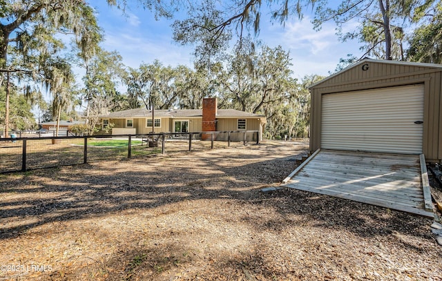 view of yard with an outbuilding, driveway, and fence