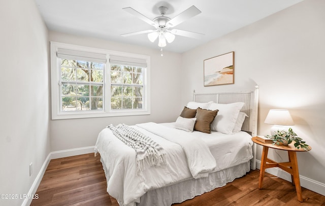 bedroom featuring ceiling fan, baseboards, and wood finished floors