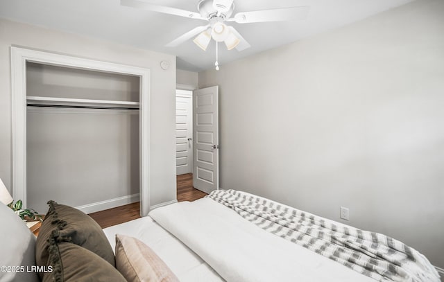 bedroom with ceiling fan, baseboards, dark wood-style flooring, and a closet