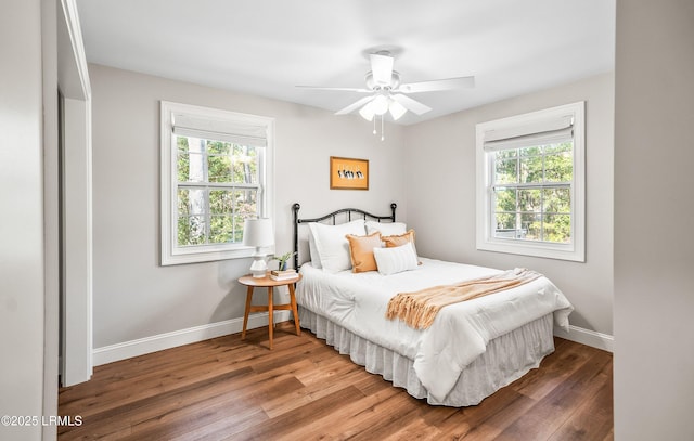 bedroom with ceiling fan, baseboards, and wood finished floors