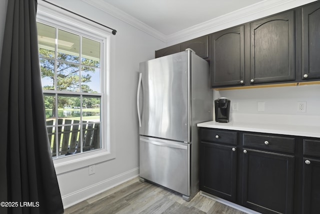 22 Sandy Pointe Dr, Bluffton, SC 29910 - kitchen featuring freestanding refrigerator, light wood finished floors, baseboards, light countertops, and crown molding