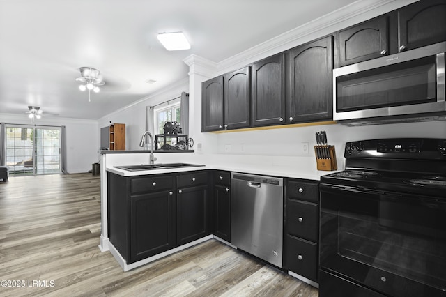 22 Sandy Pointe Dr, Bluffton, SC 29910 - kitchen with stainless steel appliances, a sink, a peninsula, crown molding, and a ceiling fan