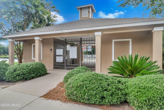 22 Sandy Pointe Dr, Bluffton, SC 29910 - view of exterior entry with stucco siding and a shingled roof