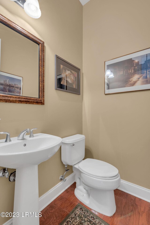 bathroom with hardwood / wood-style floors and toilet