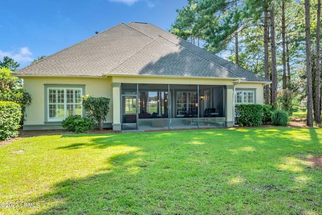 back of house featuring a lawn and a sunroom