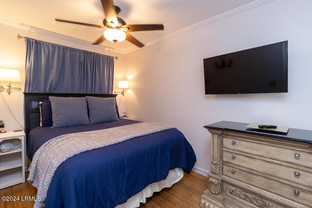 bedroom featuring hardwood / wood-style flooring, ceiling fan, and ornamental molding