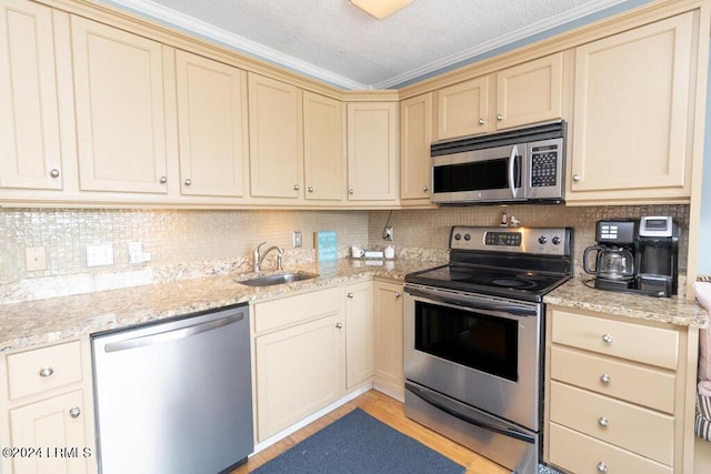 kitchen with appliances with stainless steel finishes, sink, and backsplash